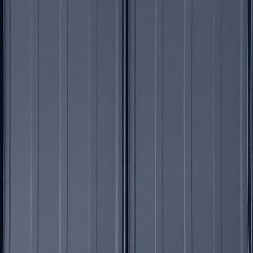 Close-up view of charcoal gray standing seam metal roofing panels with vertical striations and raised seams running parallel down the surface.