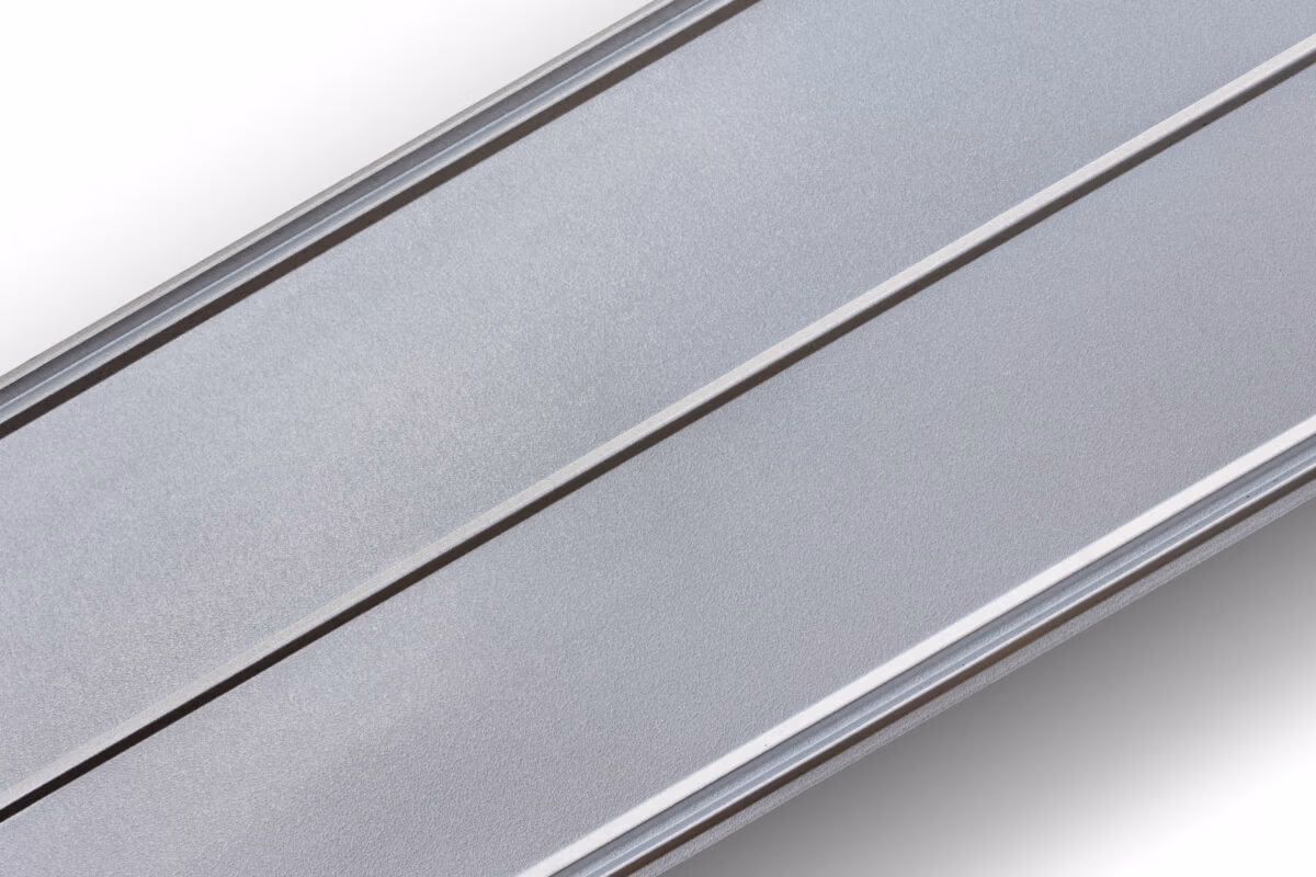 Close-up of 5-V Crimp metal roofing panels showing the distinctive V-shaped corrugated pattern and silver-gray finish