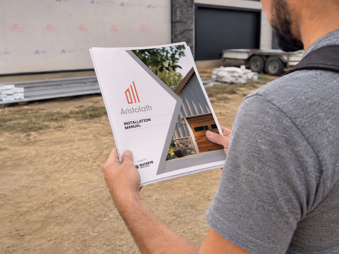 Contractor holding a white metal roofing panel sample with Buckeye Metal Sales branding while reviewing specifications