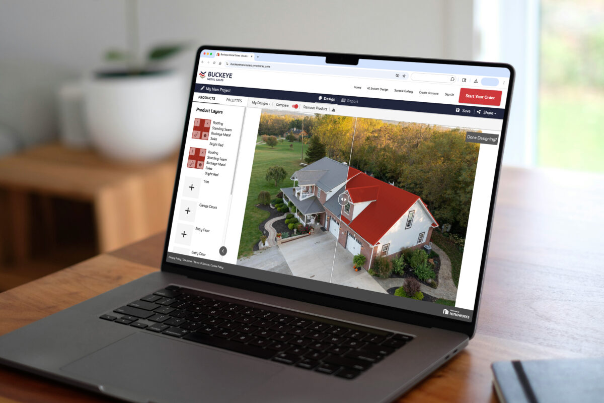 A MacBook laptop on a wooden desk displays the Buckeye Metal Sales online roofing visualizer tool, showing a split before-and-after aerial view of a white farmhouse with a bright red standing seam metal roof being digitally applied.