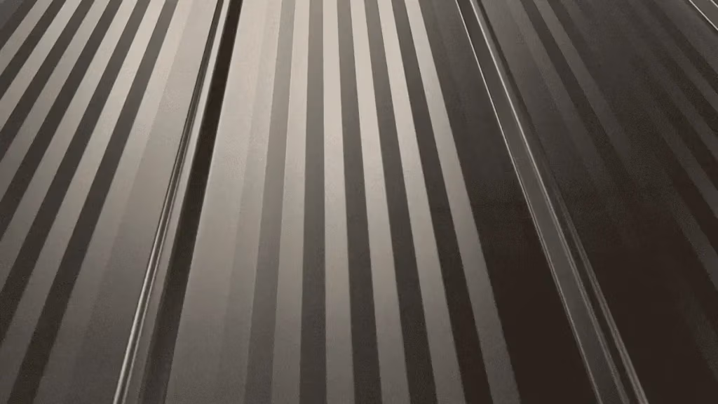 Close-up of dark matte black corrugated metal roofing panels with alternating raised ridges and flat channels showing subtle light reflections across the surface.