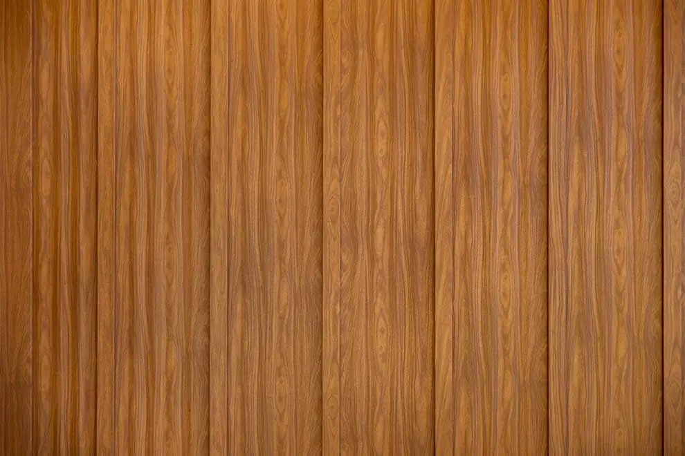 Close-up of vertical wood grain panels in a warm teak brown finish, showing natural grain patterns and subtle color variation across multiple planks.