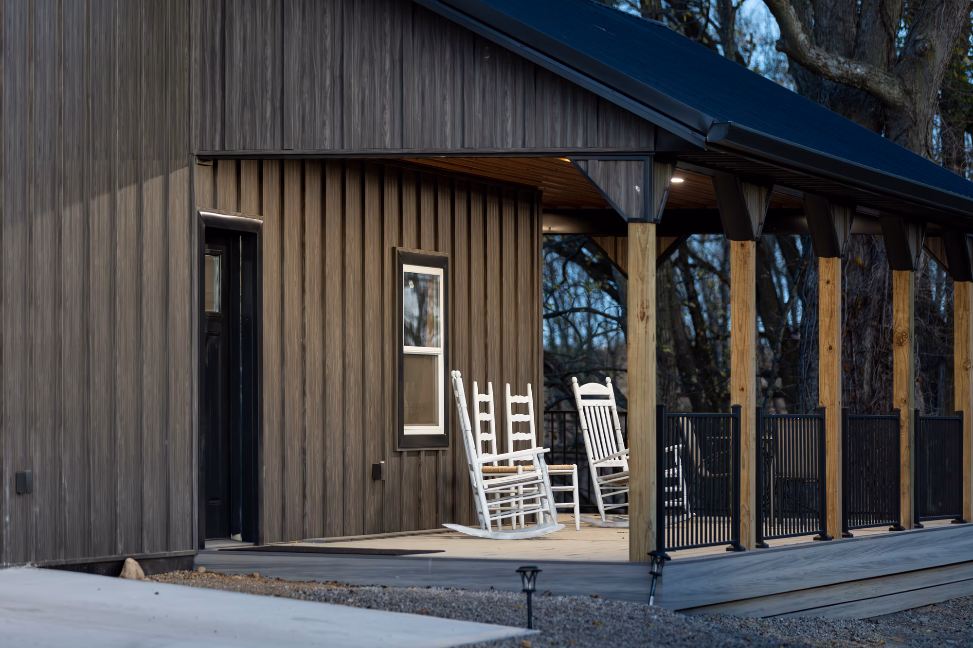 Exterior of contemporary home with vertical metal siding in wood-tone finish and large windows, demonstrating Aristolath board and batten product