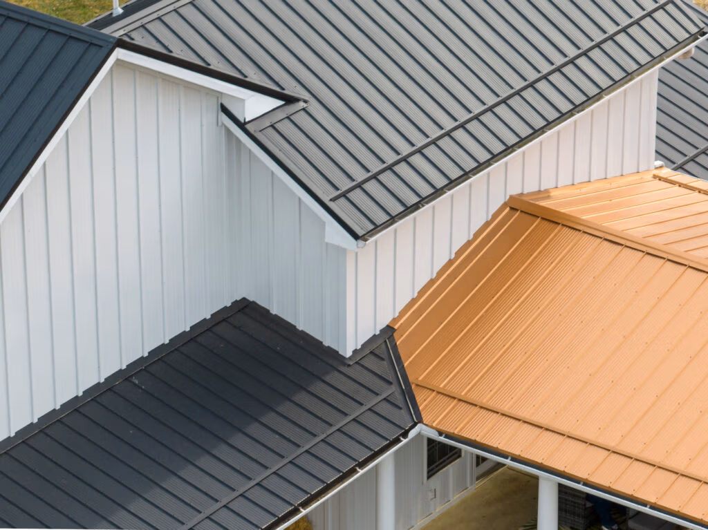 Aerial view of residential roofing showing Buckeye Wave panels with distinctive rippled texture in natural wood and charcoal tones, alongside traditional metal panels.