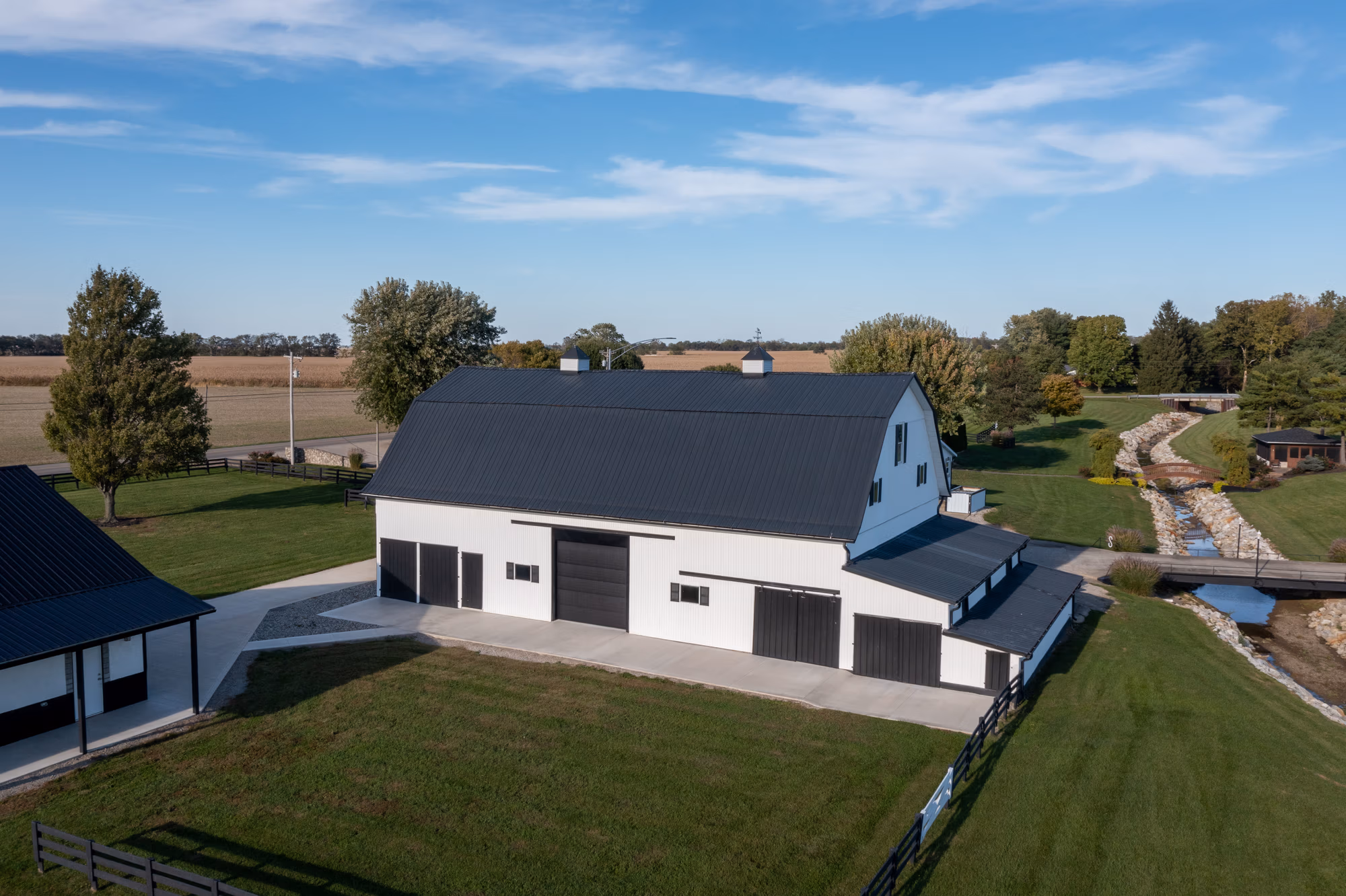 Residential home featuring dark metal roofing and white metal siding panels with a metal roof accent on the peaked gable