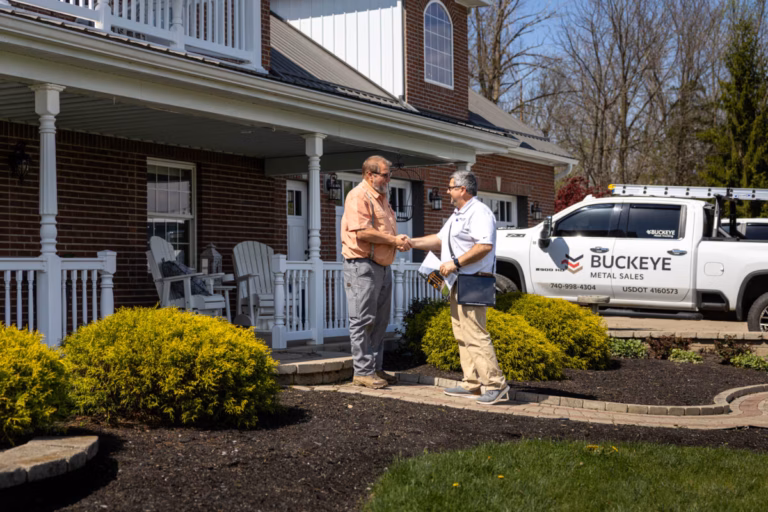 Buckeye Metal Sales technician discusses roofing materials with homeowner at front porch of residential home