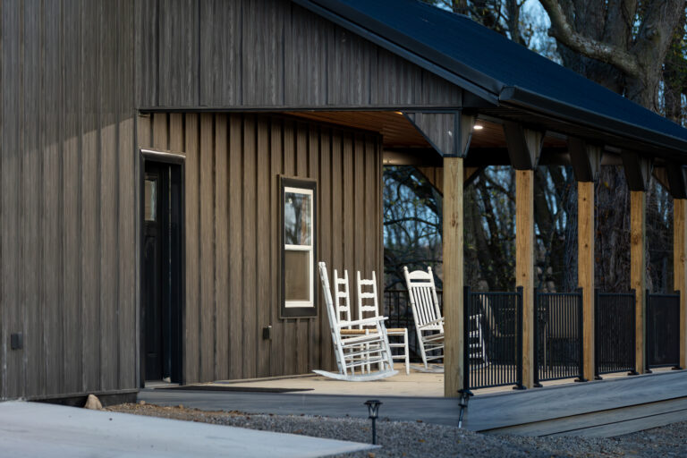 Contemporary building exterior featuring vertical metal siding panels and large windows with metal framing details