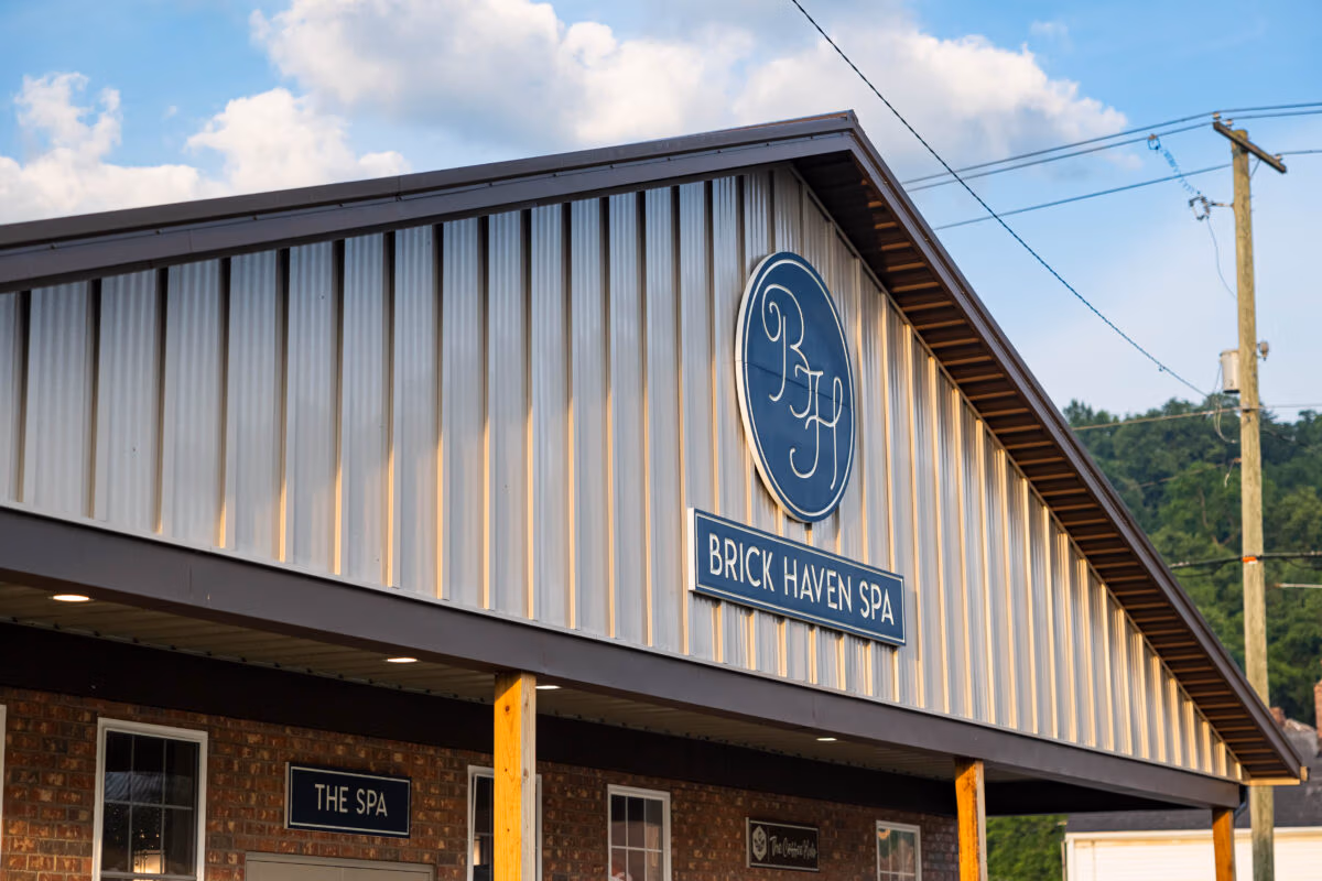Exterior of a building with vertical metal siding in gray and white, featuring the Buckeye Metal Sales logo and signage